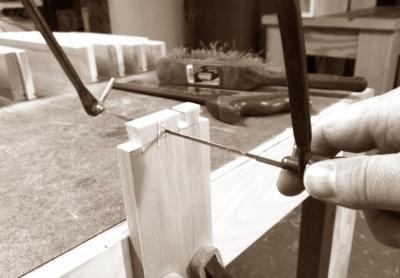 Clearing the waste between the tails with a coping saw